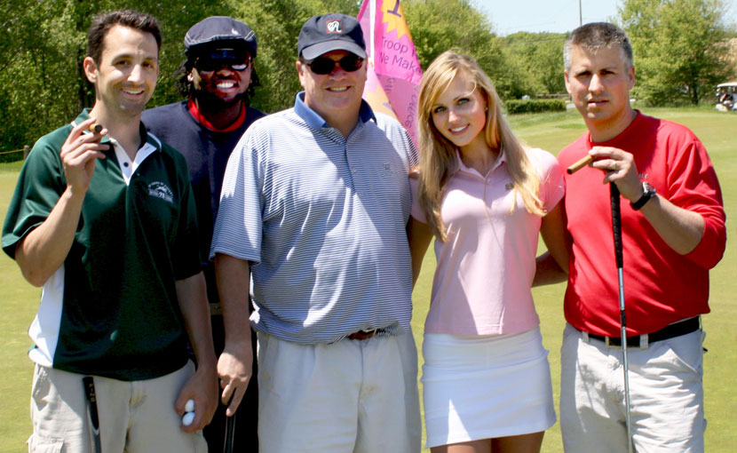 Golf foursome enjoying cigars with a cigar girl