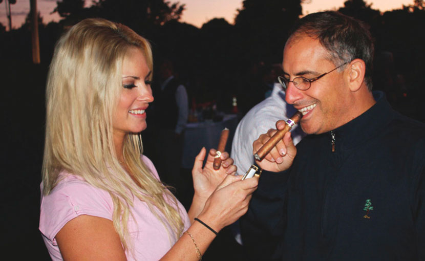 Gina Cigar Girl lighting a guests cigar